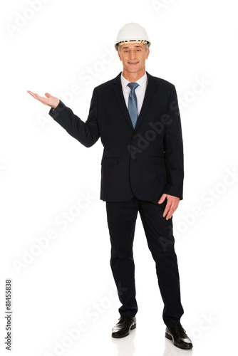 Businessman with hard hat holding copyspace
