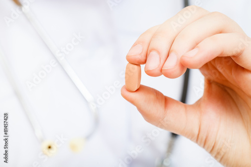 nurse holds tablet in fingers