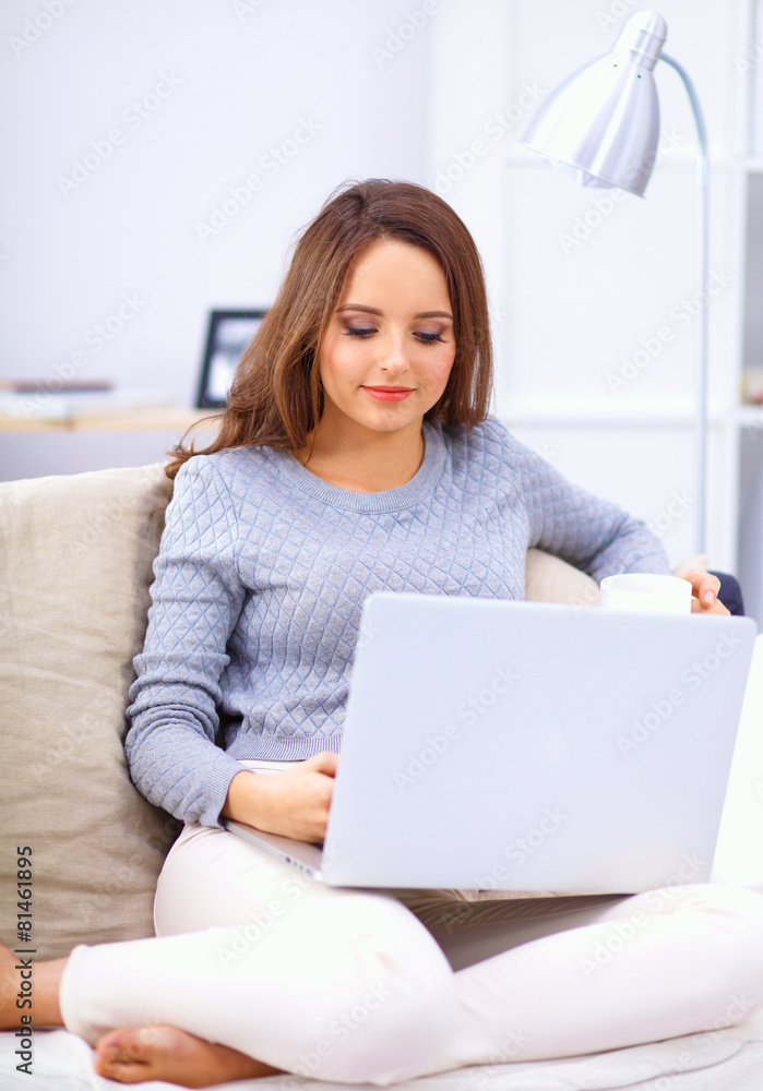 Happy pretty woman using laptop sitting on sofa Happy pretty woman using laptop sitting on sofa