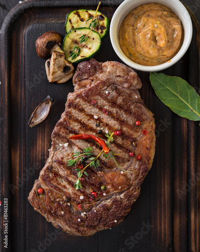 Tableau sur toile Beef rump steak on black stone table