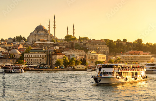 Photography Tourist boat sails on Golden Horn at sunset, Istanbul, Turkey