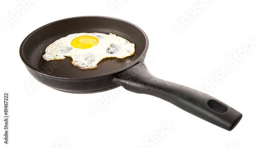 Fried egg in a frying pan over white background