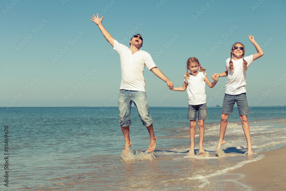 Father and daughters playing on the beach at the day time. Father and daughters playing on the beach at the day time.