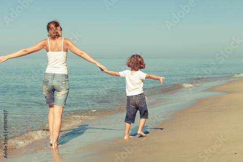Mother and son playing on the beach at the day time.