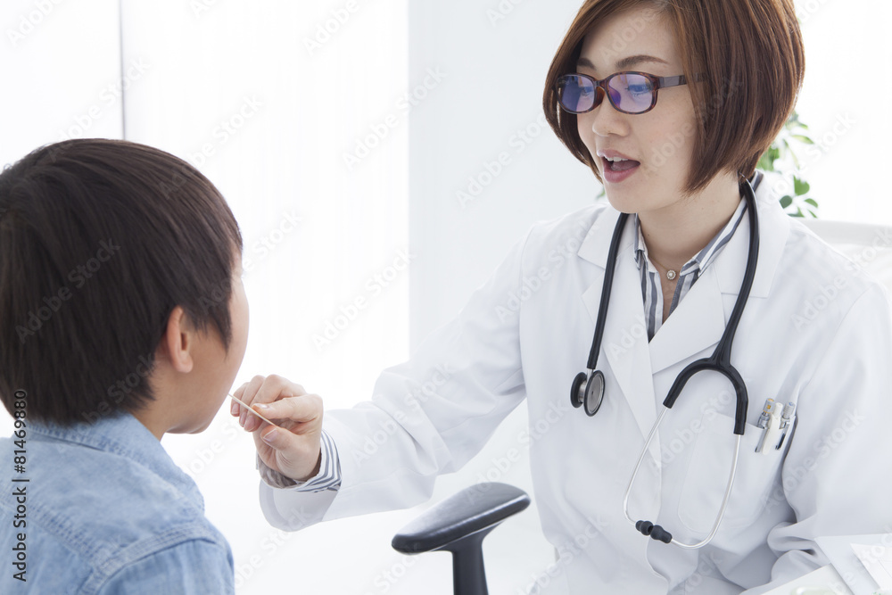 Female doctor looking at a child's throat Female doctor looking at a child's throat