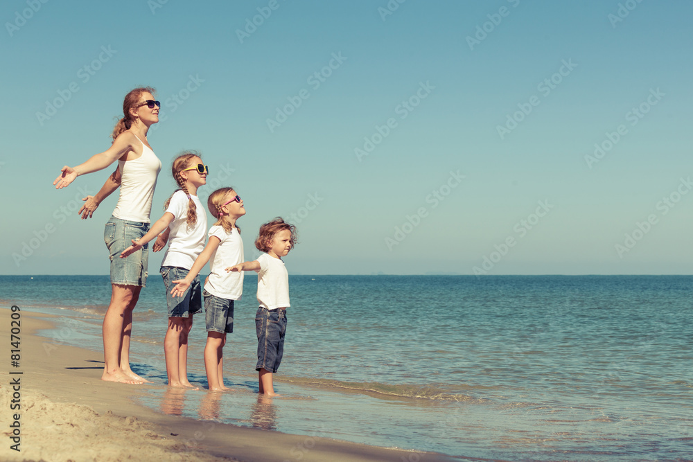 Mother and  children playing on the beach.