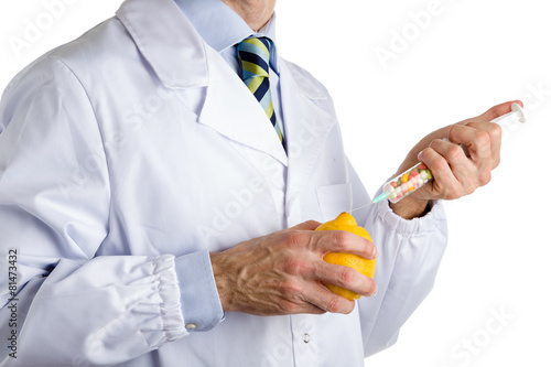 man in medical white coat makes an injection to yellow lemon