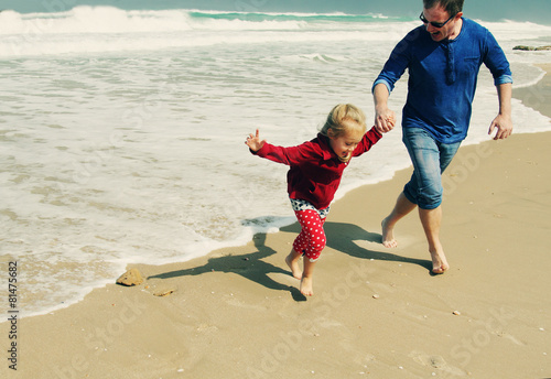 father and daughter walking on the beach