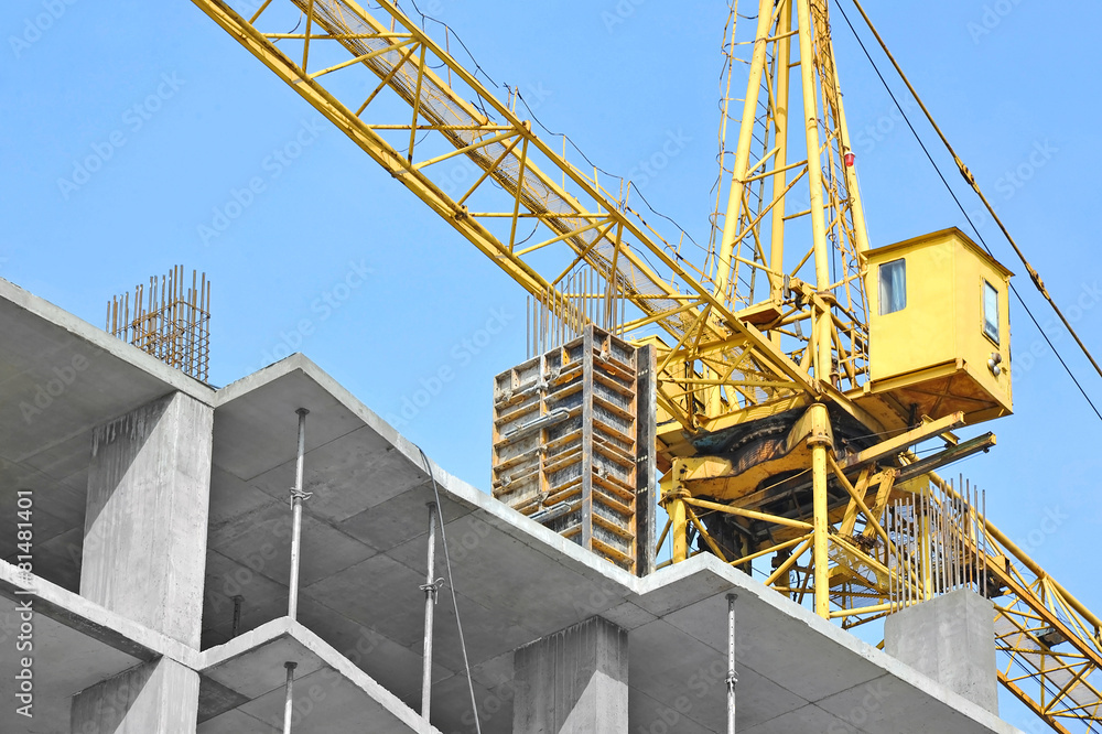 Crane and building construction site against blue sky Crane and building construction site against blue sky