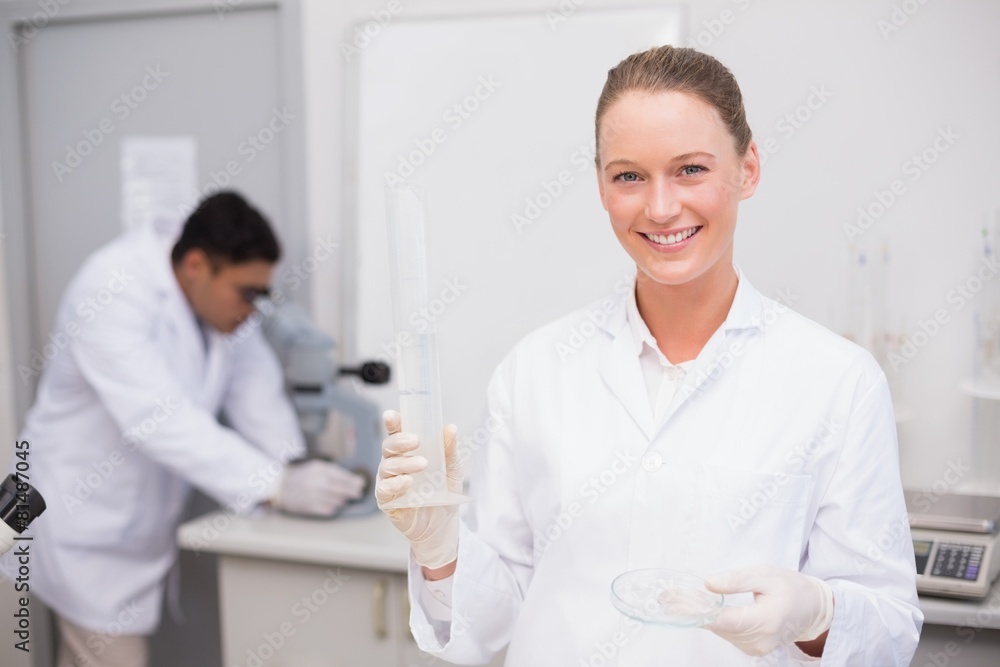 Fototapeta premium Smiling scientist filling a petri dish