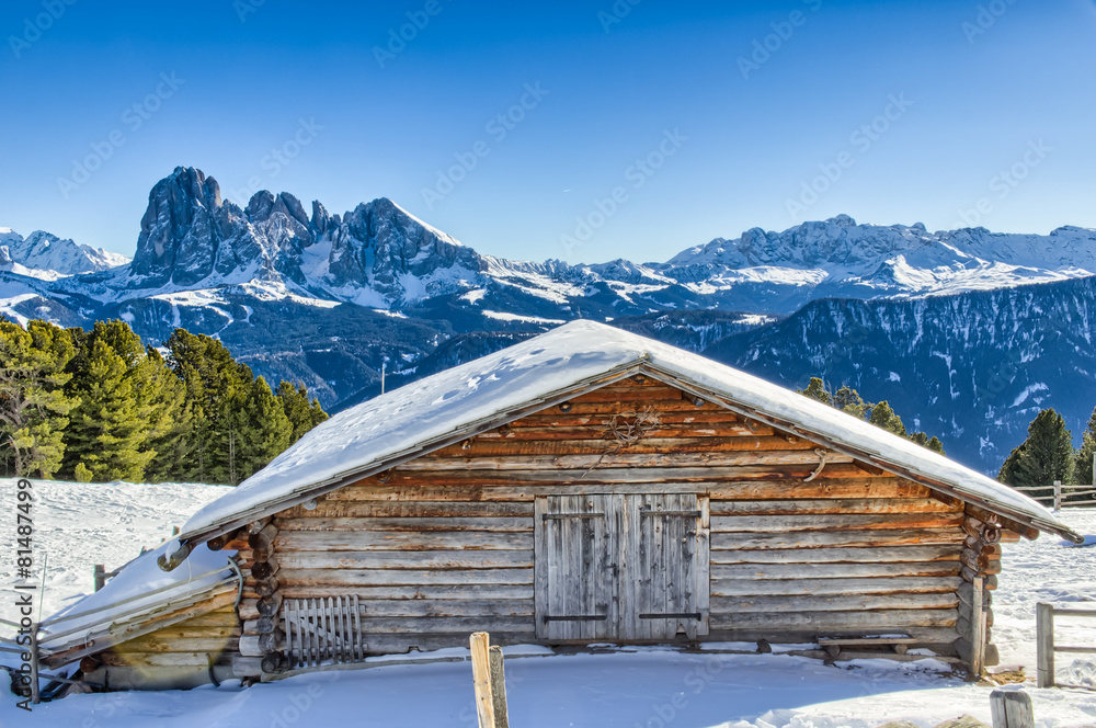 panorama of the Dolomites with wood cottage, snowy mountains and