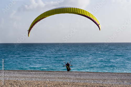 Paraglider landing on a beach.