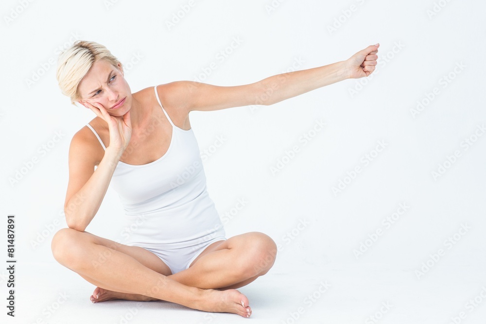 Upset woman sitting on the floor raising her arm Upset woman sitting on the floor raising her arm