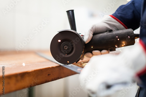 Tela Worker using a grinder