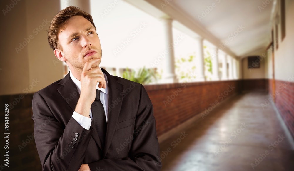 Composite image of young businessman thinking with hand on chin Composite image of young businessman thinking with hand on chin
