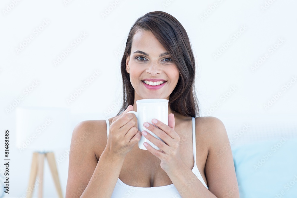 Pretty woman looking at camera holding cup of coffee Pretty woman looking at camera holding cup of coffee