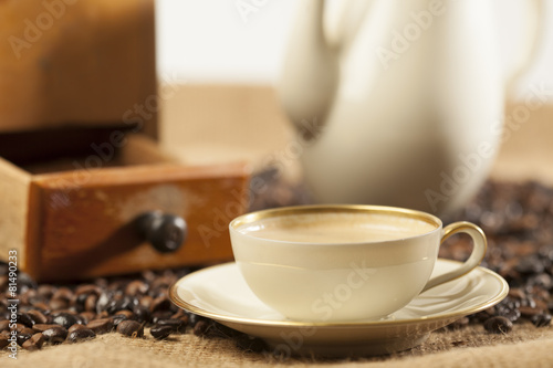 Kaffeemühle, Kaffeetasse und Kaffeekanne auf Jute