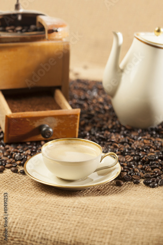 Kaffeemühle, Kaffeetasse und Kaffeekanne auf Jute