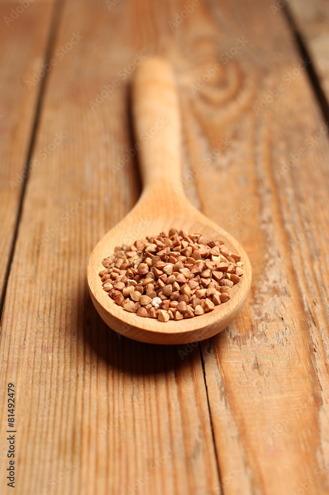 Buckwheat in a spoon on a wooden table Buckwheat in a spoon on a wooden table