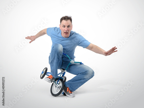Foto Curious man on a children's bicycle on white background