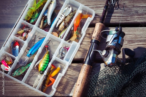 Fishing Lures in tackle boxes with spinning rod and net photo