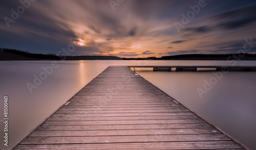 Fototapeta Naklejka Na Ścianę i Meble -  Beautiful long exposure lake with jetty at sunset.