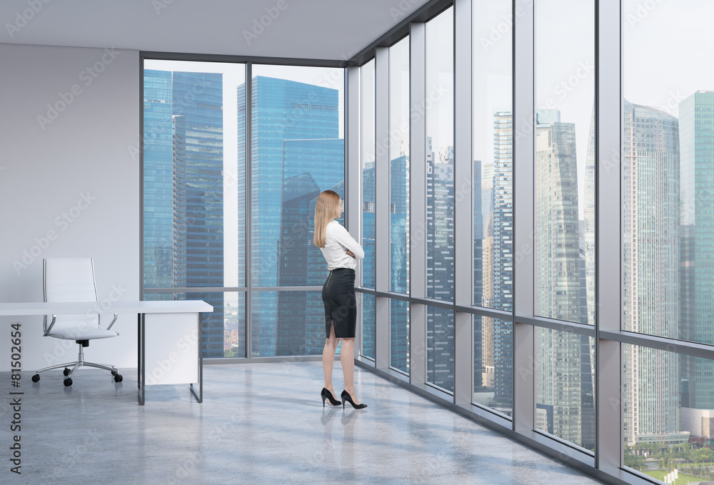 Young business woman is looking through the corner window. Young business woman is looking through the corner window.
