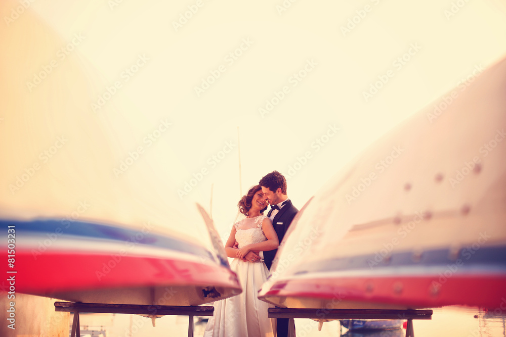 Obraz premium Bride and groom embracing near boat
