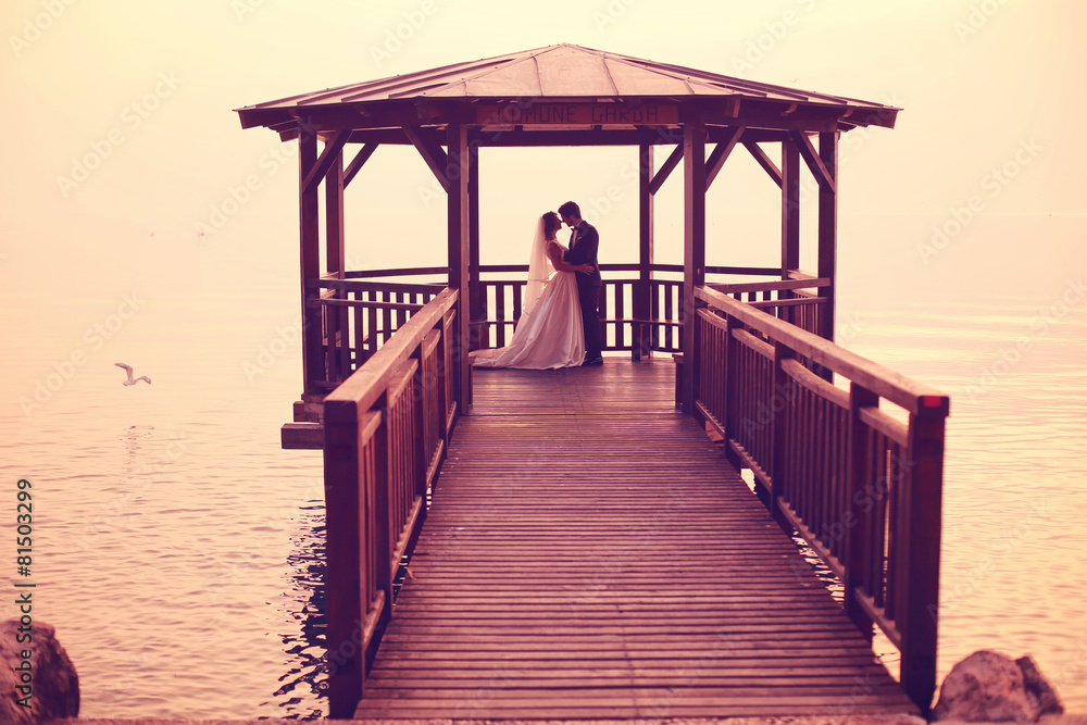 Bride and groom on wooden pier Bride and groom on wooden pier