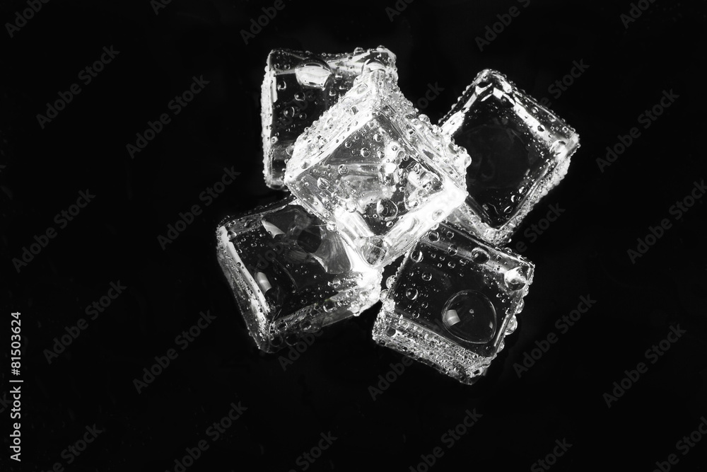 Wet ice cubes on black background. Selective focus