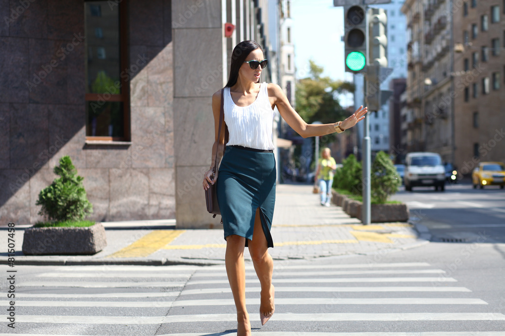 Business woman crossing the road outside