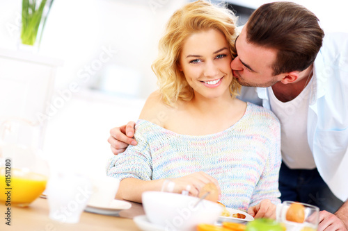 Man giving good morning kiss to his wife