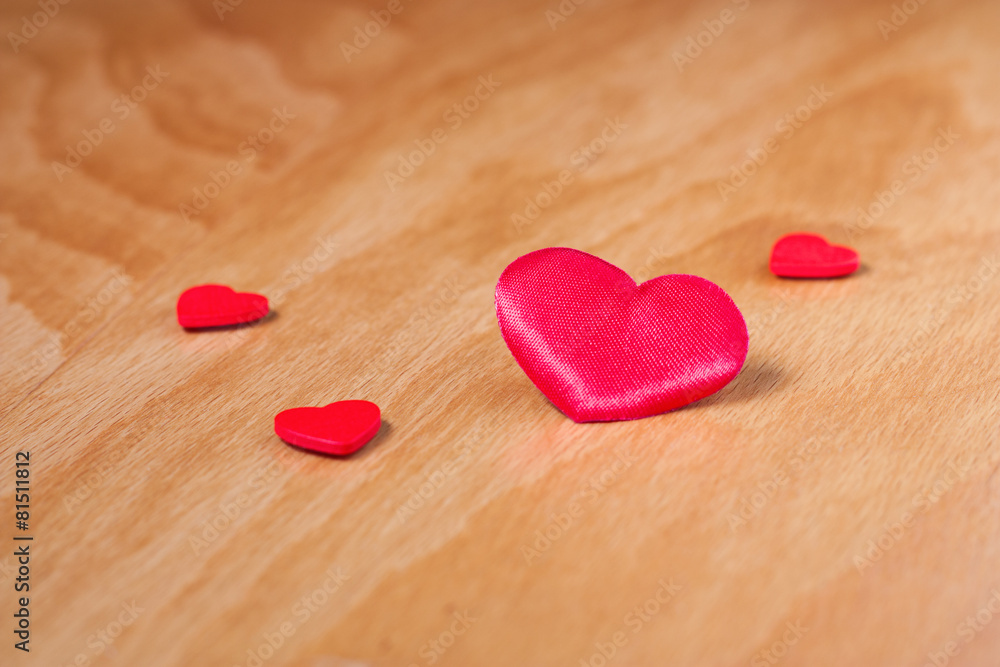Fototapeta premium Red hearts on beige wooden surface