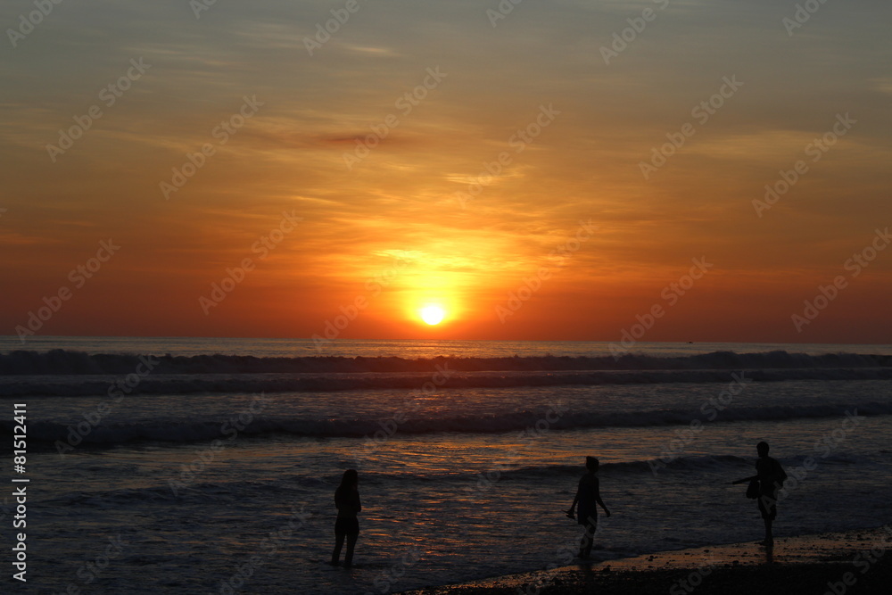 Menschen abends am Strand beim Sonnenuntergang