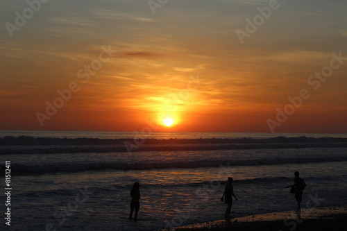 Menschen abends am Strand beim Sonnenuntergang