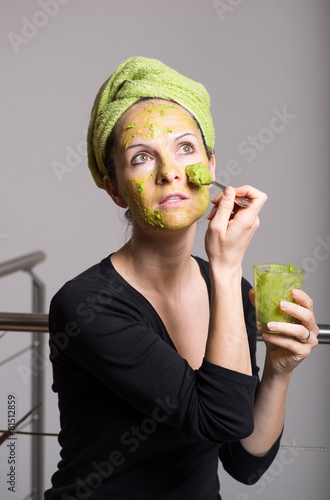 Young woman with an avocado facial mask