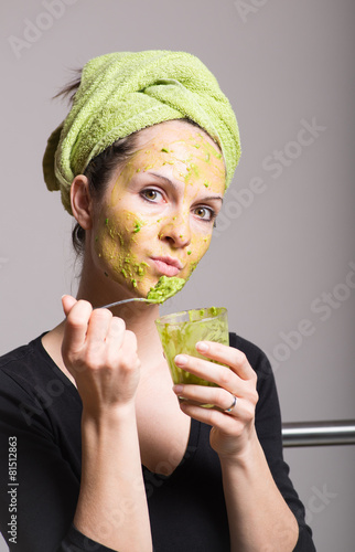Young woman with an avocado facial mask