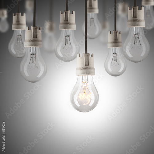 Light bulbs in row with single one shinning