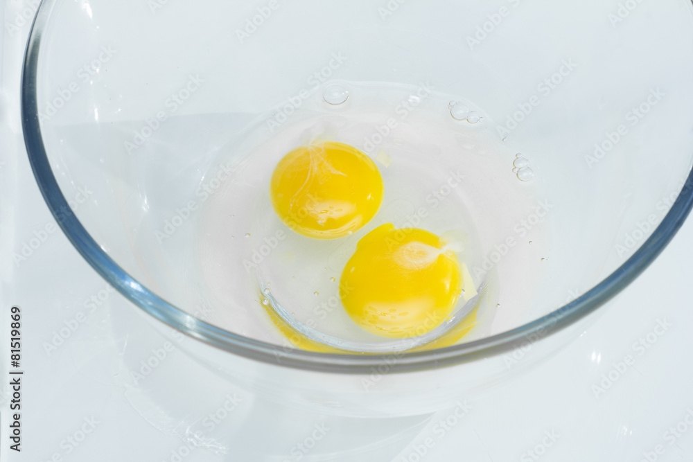Two raw broken eggs in a bowl