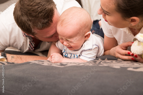 Young parents comfort her crying baby.