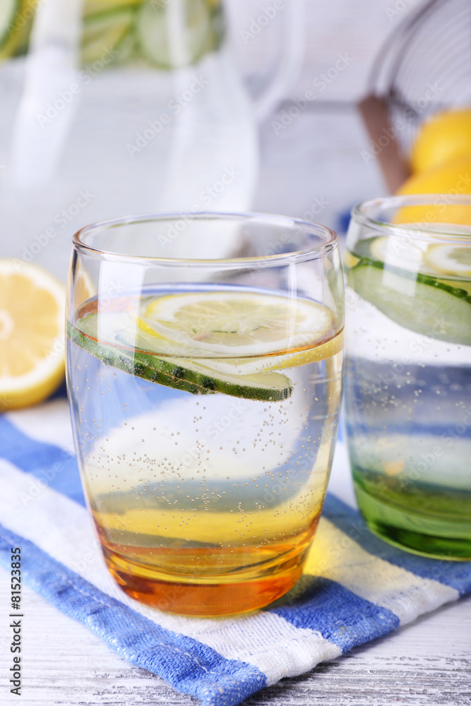 Fresh water with lemon and cucumber in glassware Fresh water with lemon and cucumber in glassware