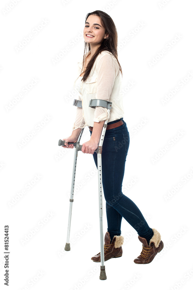 Full length portrait of young girl walking with crutches Full length portrait of young girl walking with crutches
