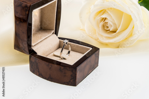 Wedding ring box and white rose on ivory silk satin © bebeball