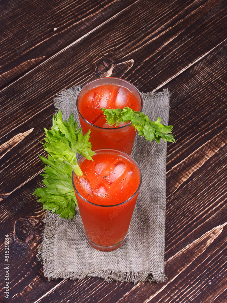 Bloody mary cocktails served with celery on wooden background Bloody mary cocktails served with celery on wooden background