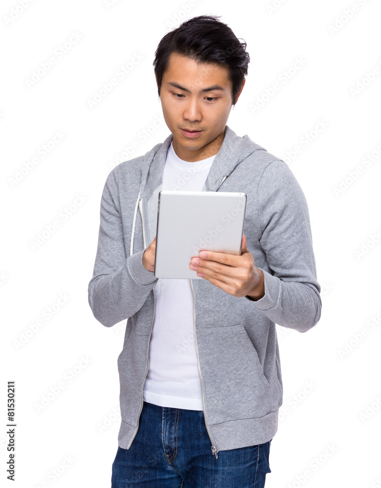 Asian man standing with tablet computer Asian man standing with tablet computer