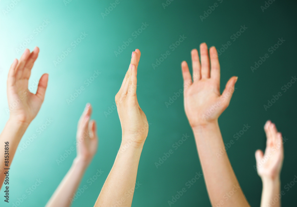 Raised hands on blackboard background in class Raised hands on blackboard background in class