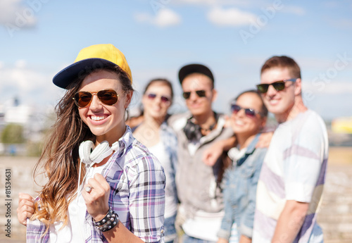teenage girl with headphones and friends outside © Syda Productions