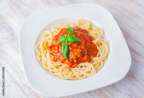spaghetti bolognese in white bowl on wooden table