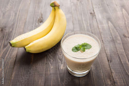 Banana smoothie on wooden table.