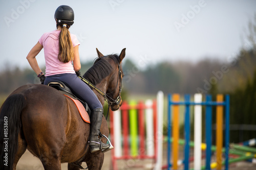 Young woman show jumping with horse